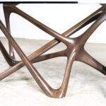 modern sculptural solid wood dining table from angled perspective