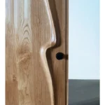 Sculptural solid wood interior door detail of white oak curve